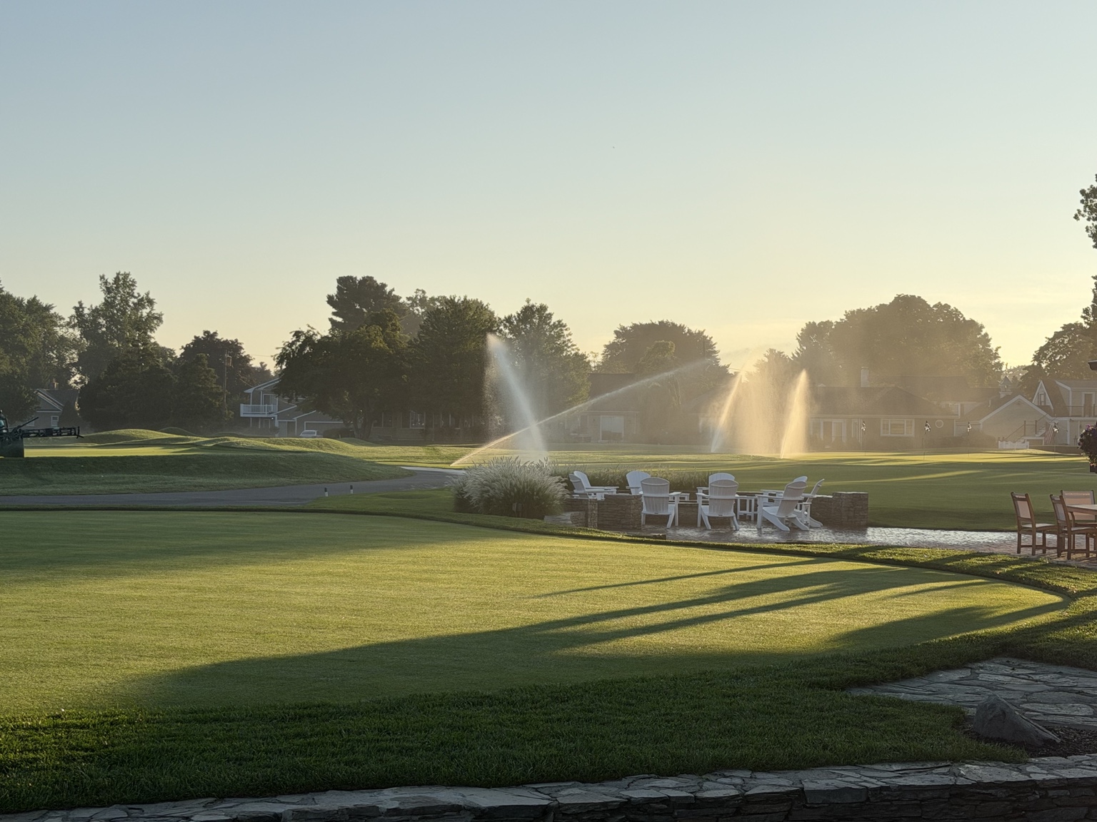 Golf course at sunrise with sprinklers running